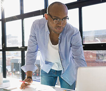 man working on his laptop is a sunlit office