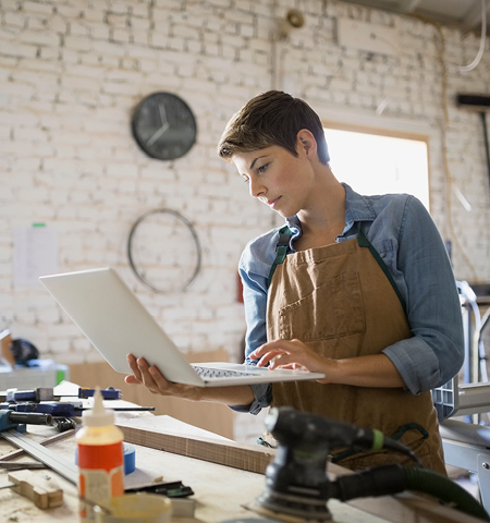 woman in a workshop working on a laptop