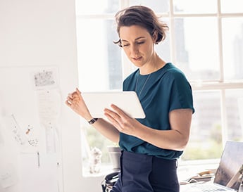 woman in a sunny office working on her tablet