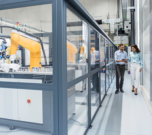 man and woman walking in a factory, talking about a document