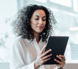 Woman smiling, working on a tablet