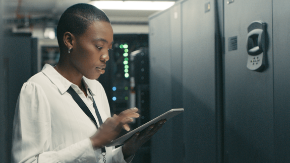 Woman looking at an ipad in a server room