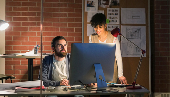 a man and a woman working together on a computer