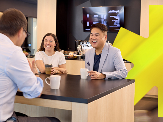 Group of 3 colleagues drinking coffee with a yellow leaf in the background