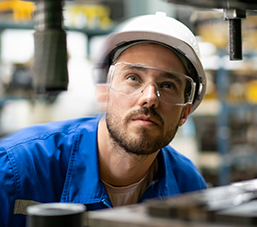 Man in factory assessing a machine