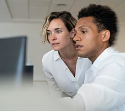 Two colleagues discussing content on a screen