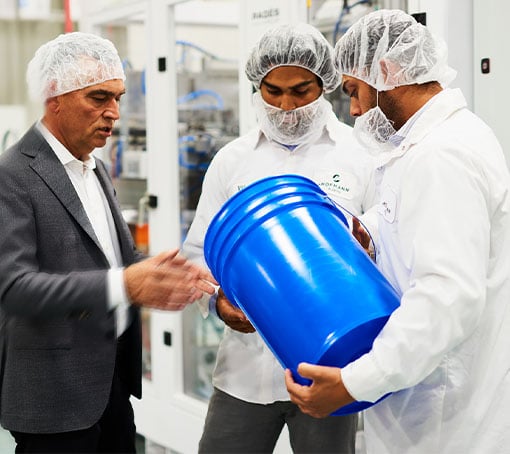 men from hofmann discussing , one's holding a blue bucket