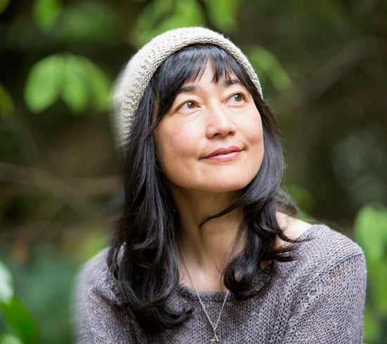 Hopeful asian woman with trees in the background