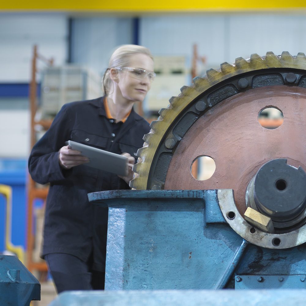 Engineers repairing an industrial gearbox in a factory