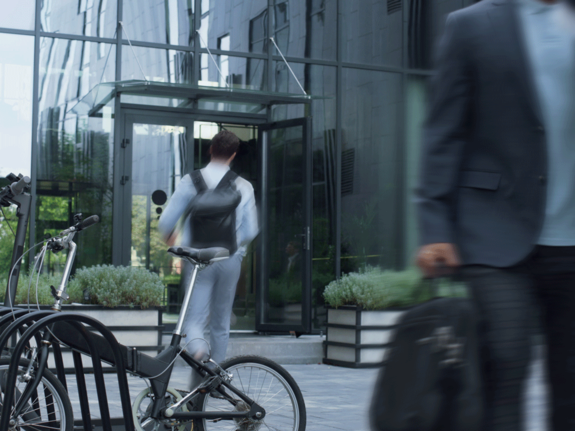 man parking his bike next to the office