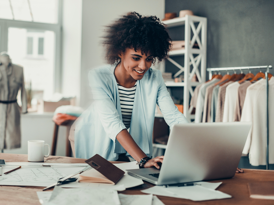 Woman entrepreneur answering clients on her laptop