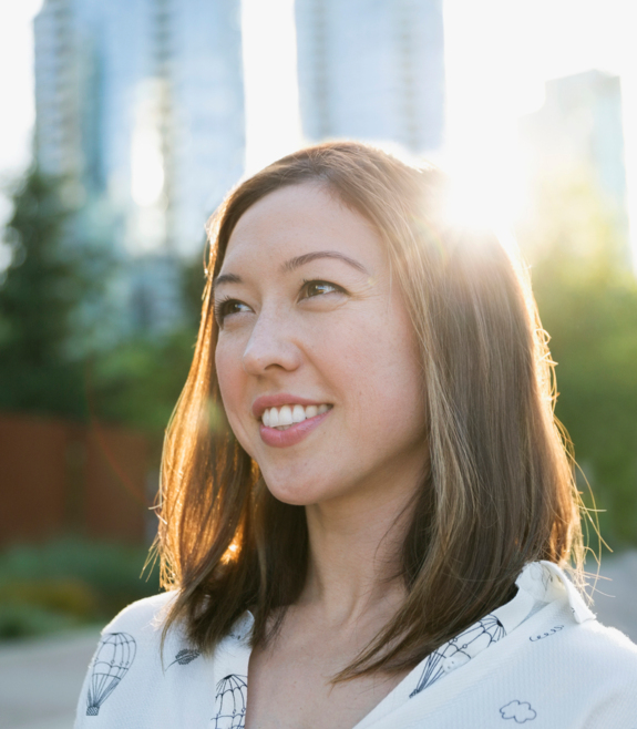 jeune femme souriante, le soleil brille derrière elle