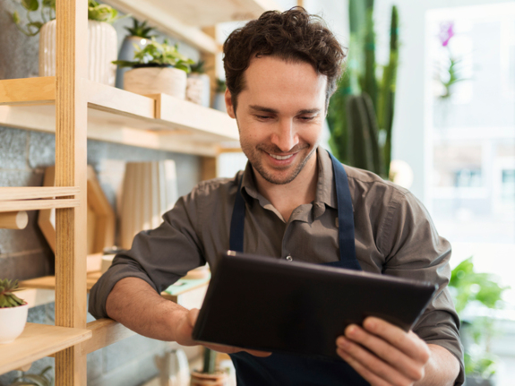 Fleuriste utilisant une tablette numérique dans un magasin de fleurs